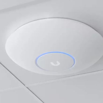 Point d'accès Wi-Fi UniFi monté au plafond, anneau lumineux allumé, intégré à la dalle sans boîtier apparent.